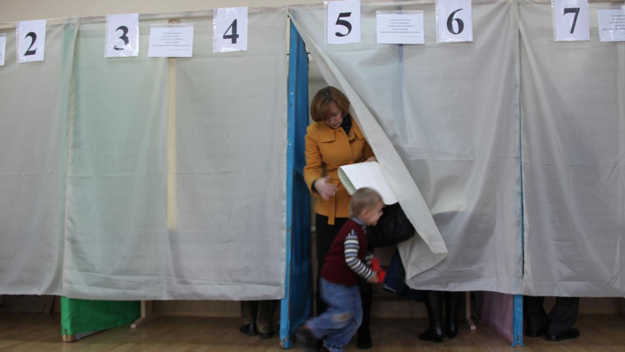 Kvinna röstar i vallokal i Ukraina.