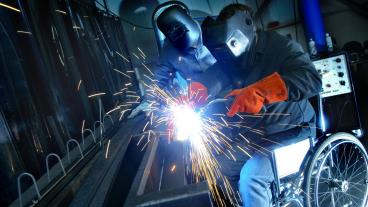 Rullstolsbunden person svetsar