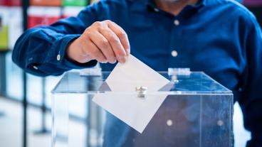 Man som lägger i röstsedel