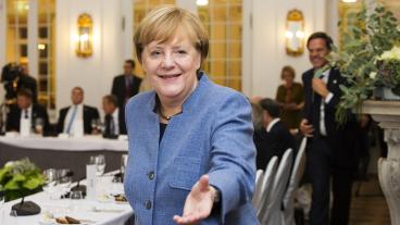 Tysklands förbundskansler Angela Merkel sträcker ut en hand till Frankrikes president Emmanuel Macron. 