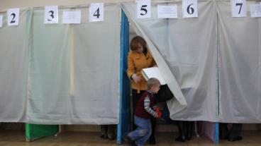 Kvinna röstar i vallokal i Ukraina.